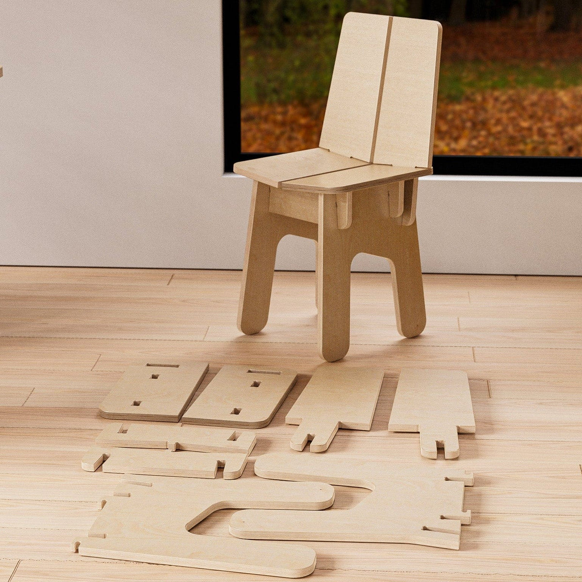 Assembled BURIJ natural wood chair displayed behind its precisely cut flat-pack components arranged across the floor