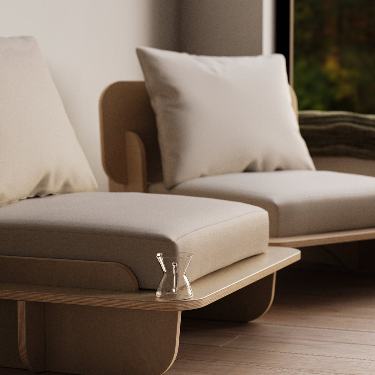 Close angled view of the Franklin Low Seater’s white cushions, curved wood arm panel and extended platform base