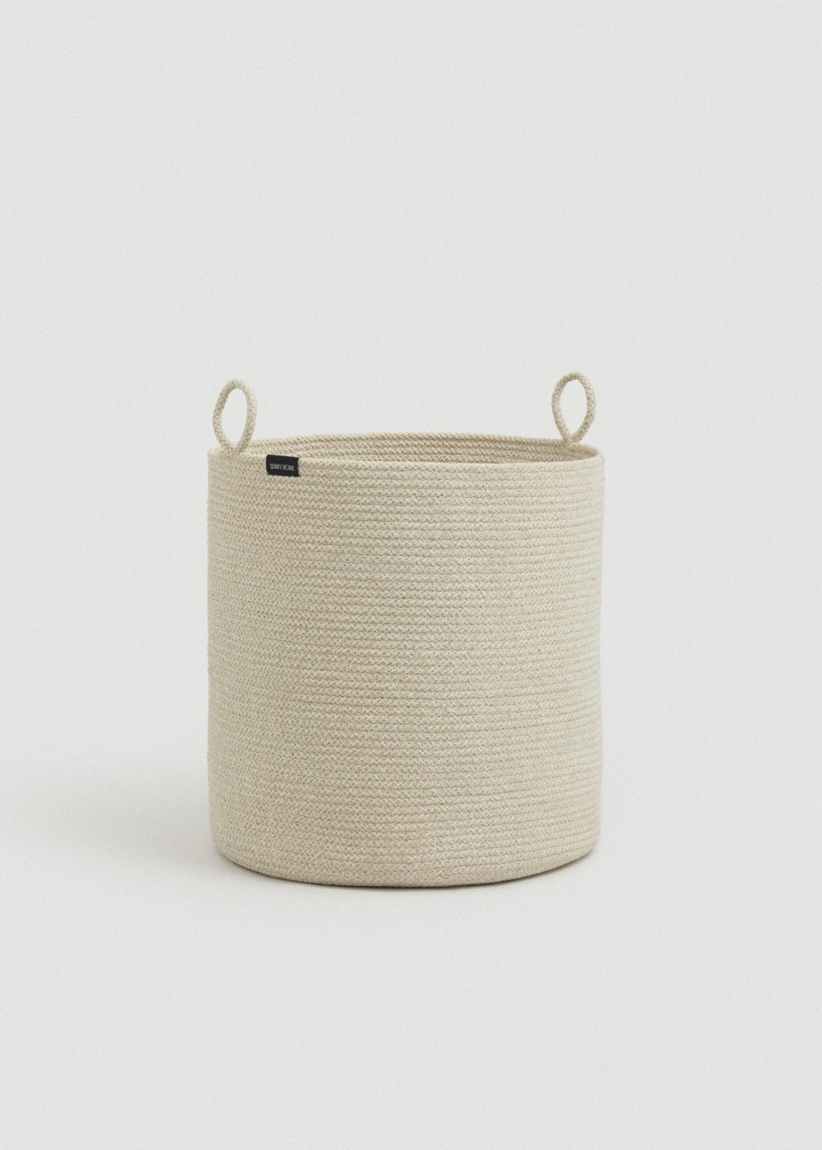 Tall beige rope basket displayed alone against a light neutral background.