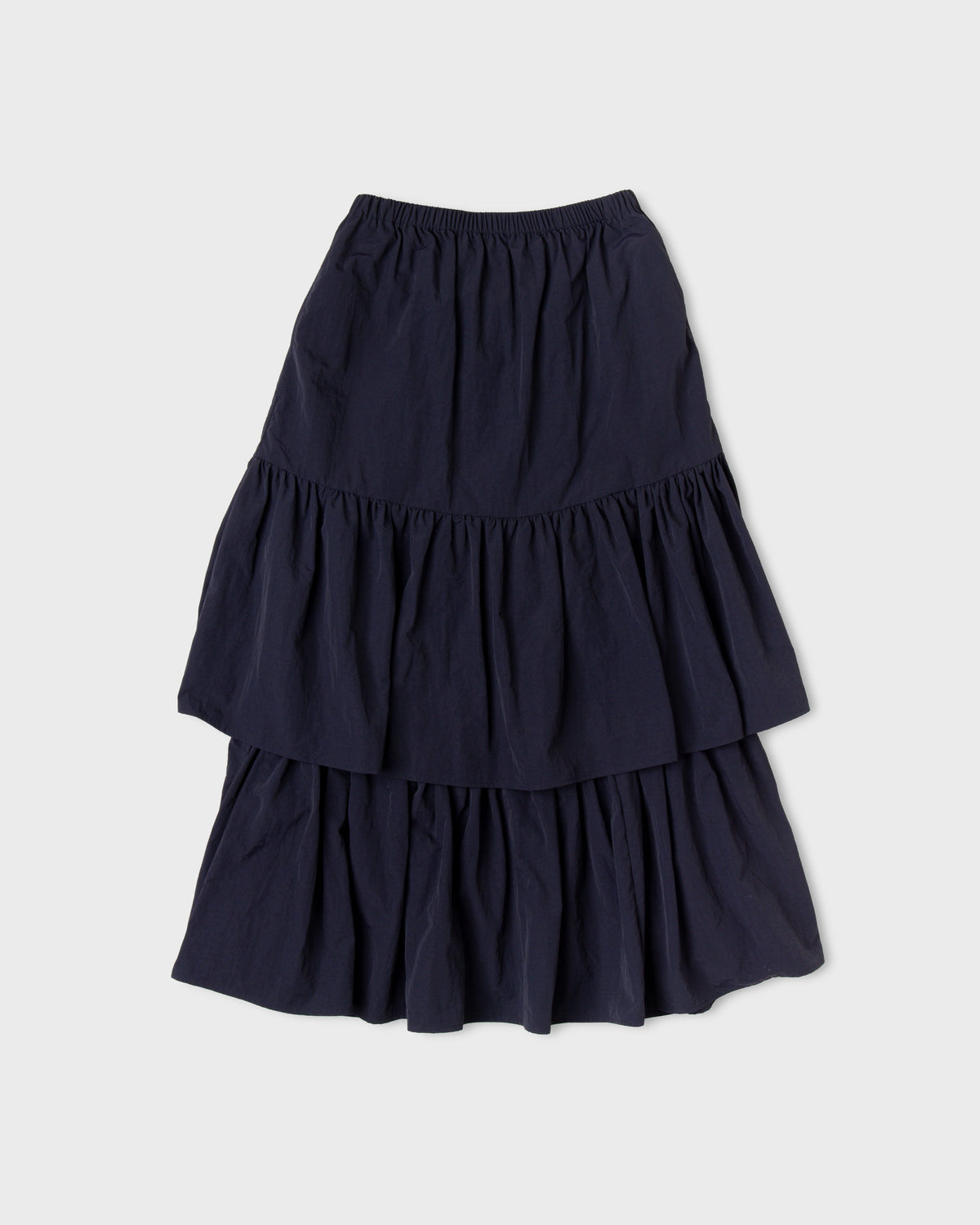 Dark navy Paulette Louise Tier Skirt displayed against a light background, showing a gathered waistband, a gently flared upper section, and two full gathered tiers.