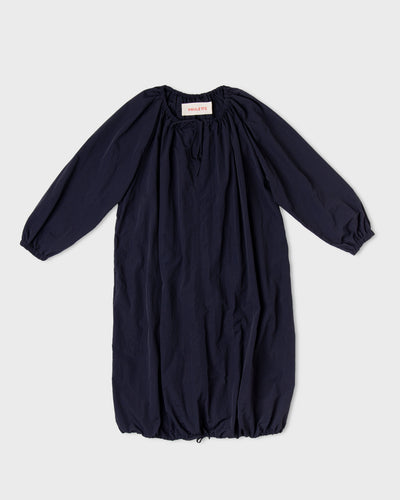 Dark navy Paulette Georgia Dress displayed against a light background, showing gathers around the neckline, voluminous long sleeves, narrow cuffs, and a rounded skirt gathered at the hem.
