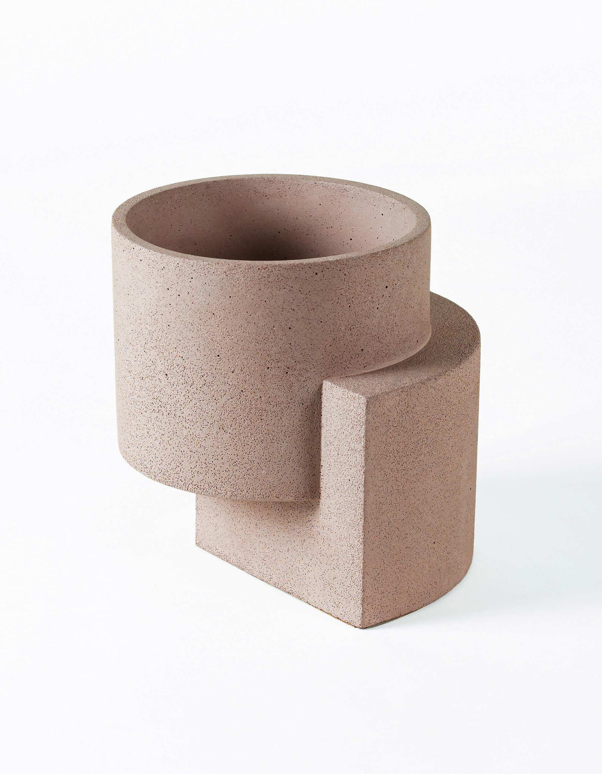 Coral Tortuga Forma Platform Planter Medium Terrazzo viewed at an angle on white, showing a speckled cylindrical bowl joined to an offset curved slab that extends beneath it as a raised base.