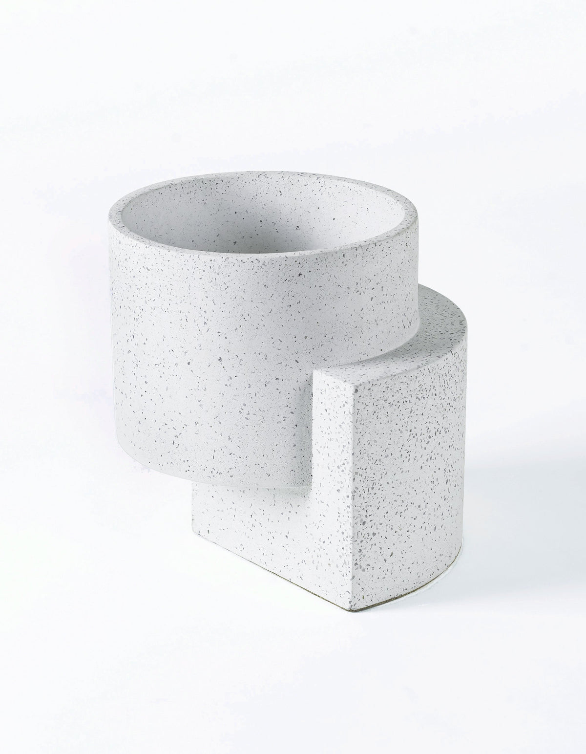 White Tortuga Forma Platform Planter Medium Terrazzo viewed at an angle on white, showing fine grey flecks, an open cylindrical bowl and an offset slab support with a curved outer edge.