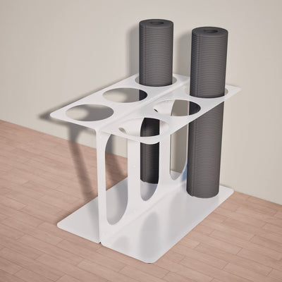 White six-slot floor stand holding three rolled gray yoga mats or foam rollers, viewed from above at an angle.