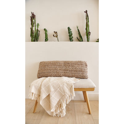 Sea Shell White textured throw draped over a small bench beneath a wall shelf decorated with slender green plants