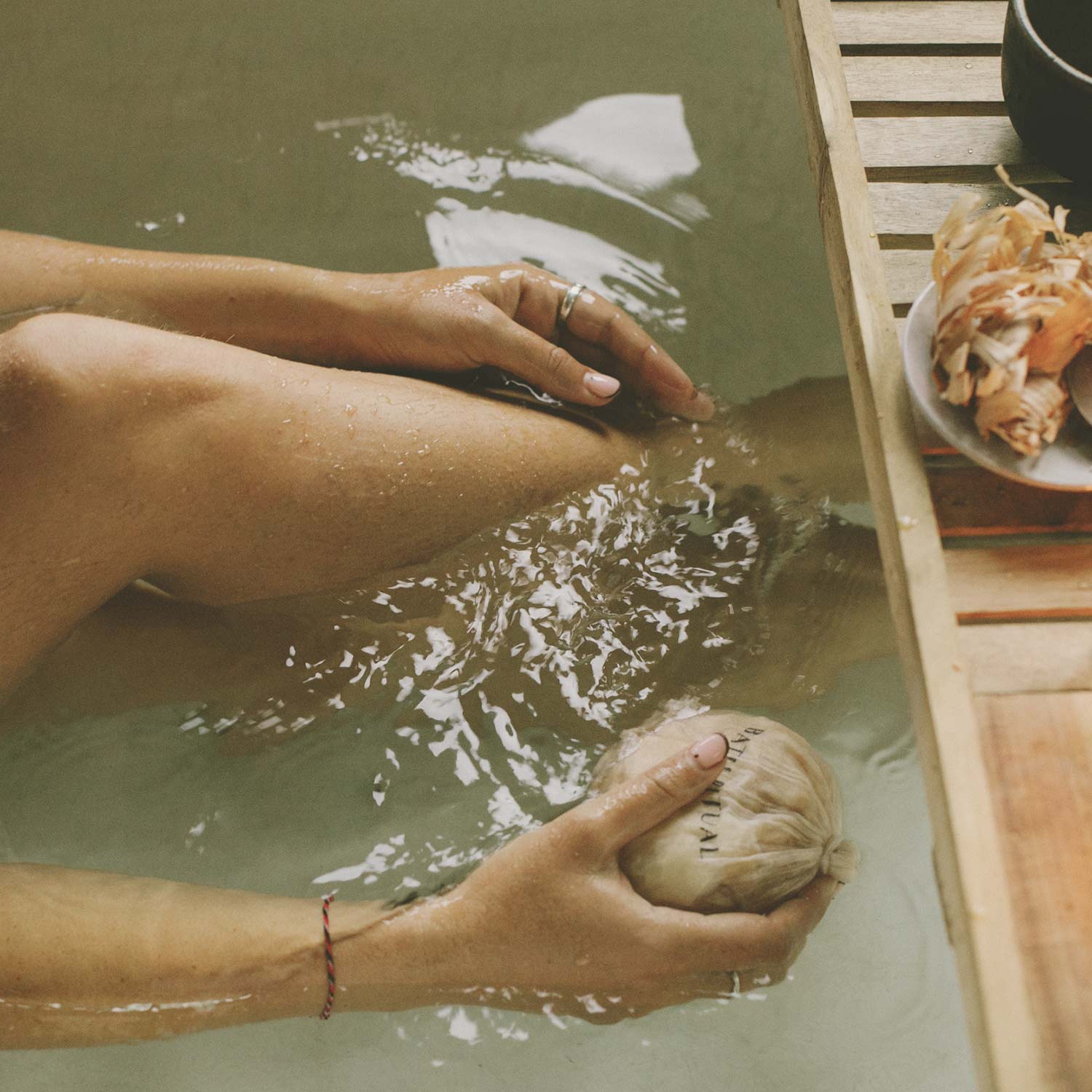 Sugi Japanese Bath Flakes in bath tub in the water