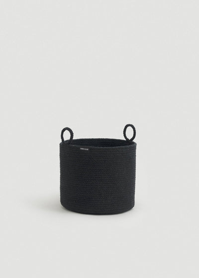 Tall black cotton rope storage basket with a cylindrical shape and two upright loop handles.