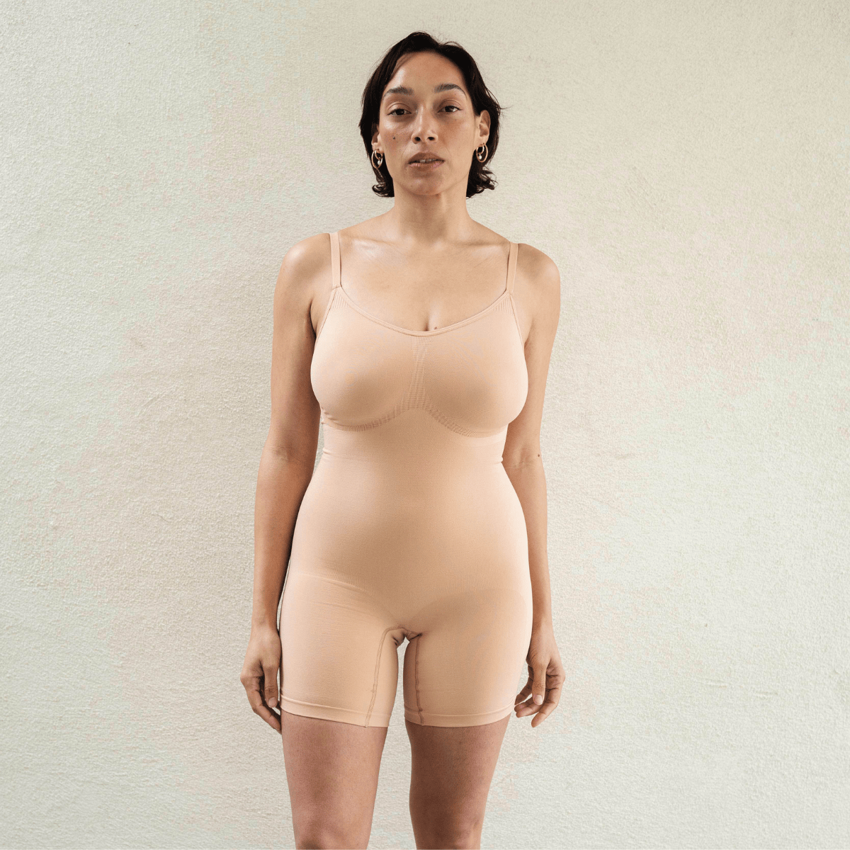 Model wearing PROCLAIM Mid-Thigh Shapewear Bodysuit in Ada Nude, front view
