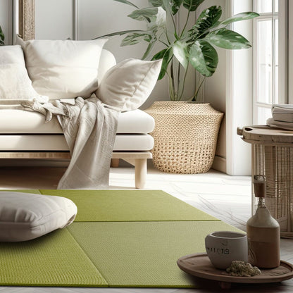A Saien green Japandi tatami mat laid out on the floor in a living room setting with a sofa, plant, and decorative items.