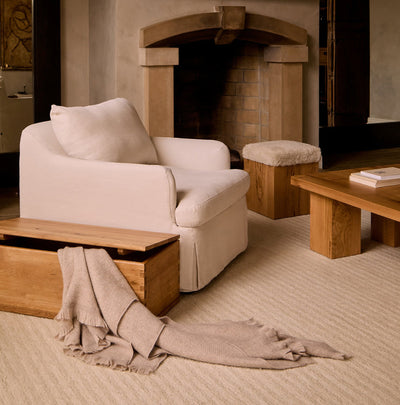 Antwerp Arm Chair with a wooden coffee table and ottoman in a living room setting by House of Leon.