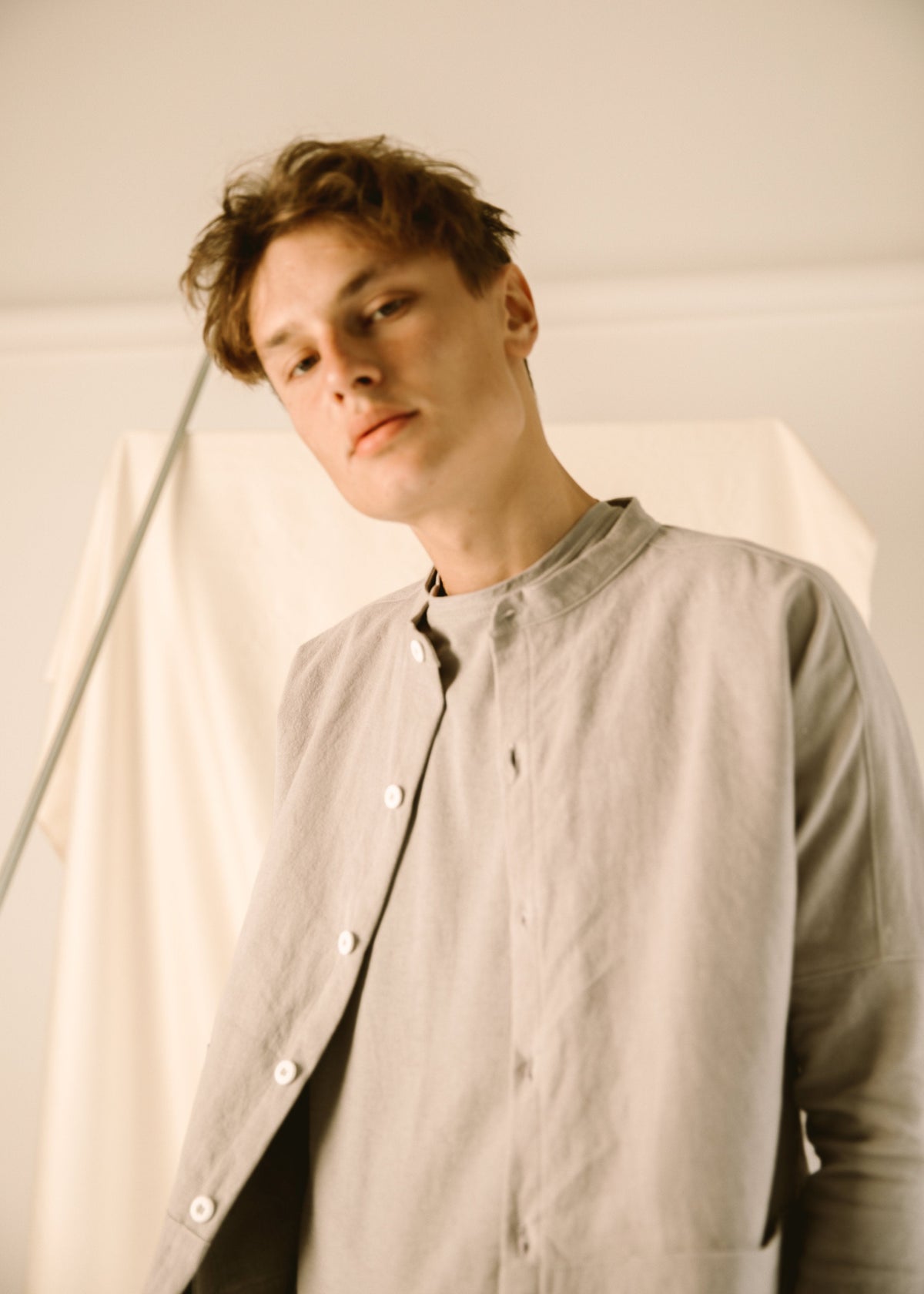 Close-up of a model wearing the light gray corduroy coat partly open.