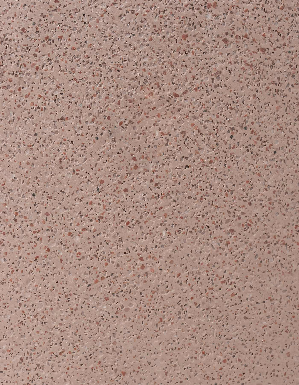 Close-up of the coral Tortuga Forma Platform Planter Medium Terrazzo finish, showing dense reddish-brown and pale flecks across a pink background.