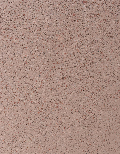 Close-up of the coral terrazzo finish on the Tortuga Forma Platform Planter Small - Terrazzo, showing densely scattered reddish-brown and pale flecks across a pink background.