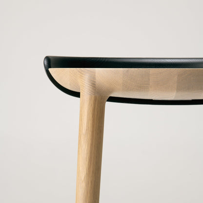 Close-up of CRUST collection showing curved oak seat and black edge detail — handcrafted Japanese-Japandi furniture.