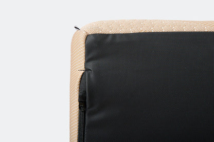 Close-up of a beige fabric surface with a black zipper on a light gray background