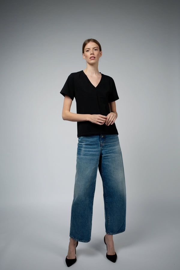Santicler Magda Organic Cotton V-Neck T-Shirt in Black – model wearing V-neck tee with wide-leg blue jeans, full front view, Japandi capsule wardrobe essential