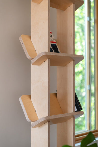 Close-up of the Yankel bookcase showing its central wood supports and upward-angled shelves designed to hold books securely