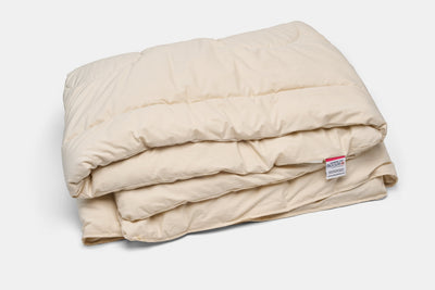 Folded American Blossom Linens natural wool duvet insert in an undyed cotton shell