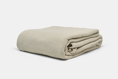 Folded Herringbone blanket on a light gray background