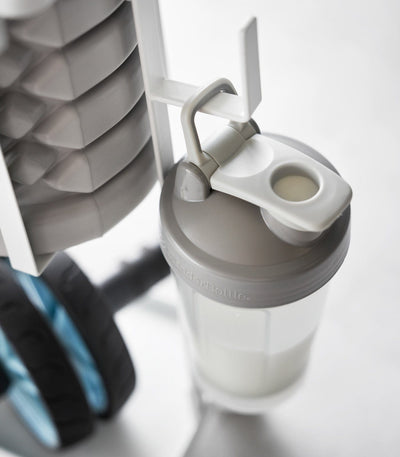 Gray shaker bottle with a white background hanging on a hook