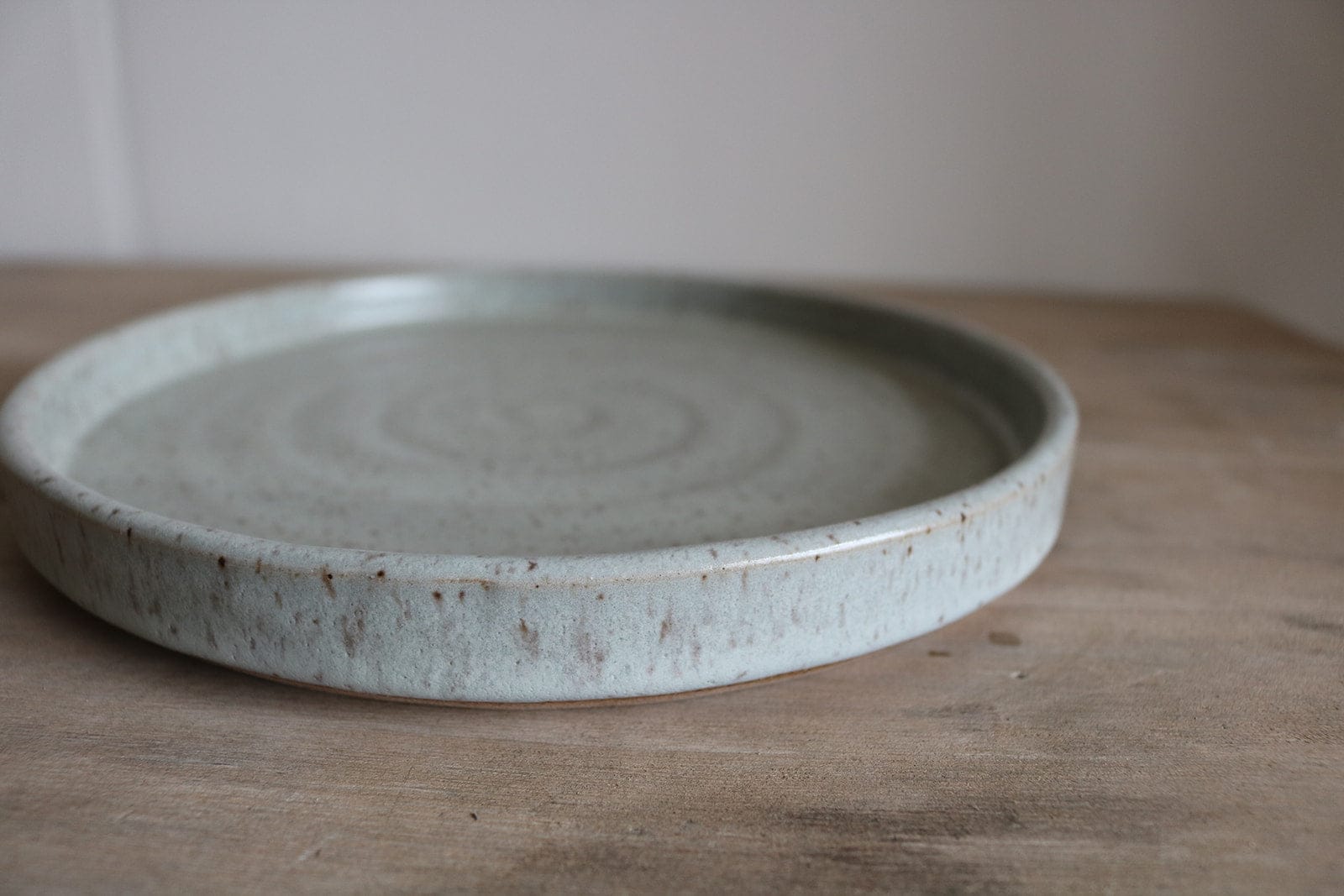 Gray speckled handmade small earthenware plate side profile