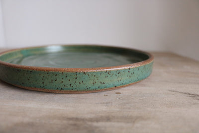 Green handmade earthenware small plate side view
