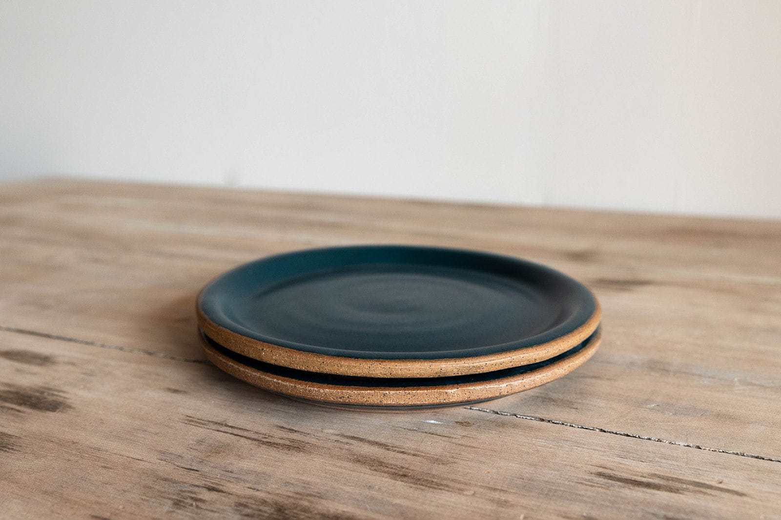 Handmade earthenware dinner plate stack with dark blue glaze