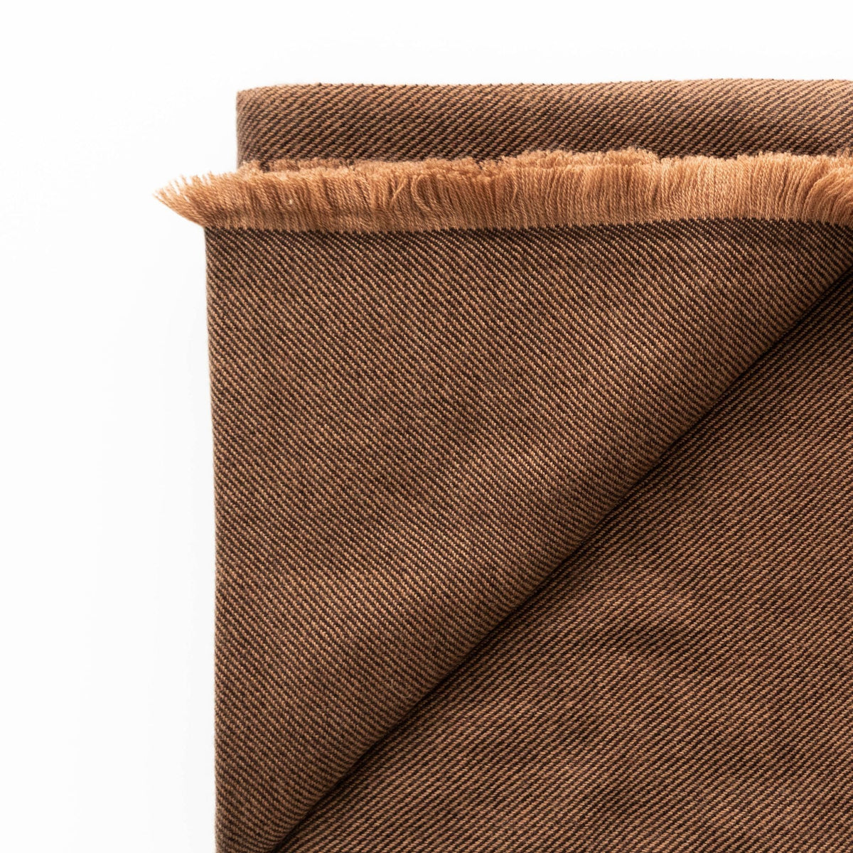 Folded corner of the Hay Brown merino throw showing its two-sided twill texture and soft fringed edge