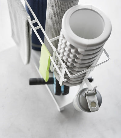 Home gym organizer cart beside sofa with yoga mat and workout gear overhead view