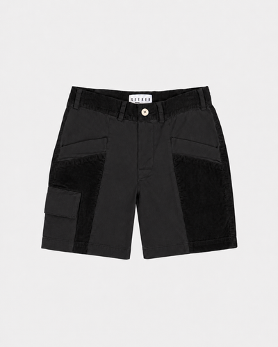 Front product view of black Trek Shorts with tonal panels and a buttoned cargo pocket.