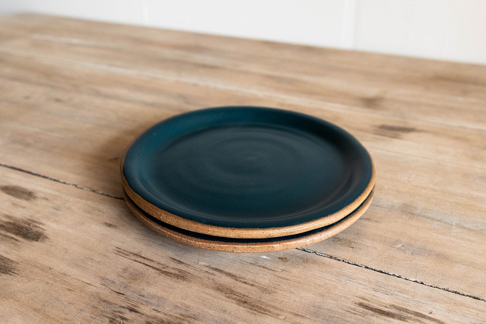 Indigo glazed handmade small plate stacked on wooden surface