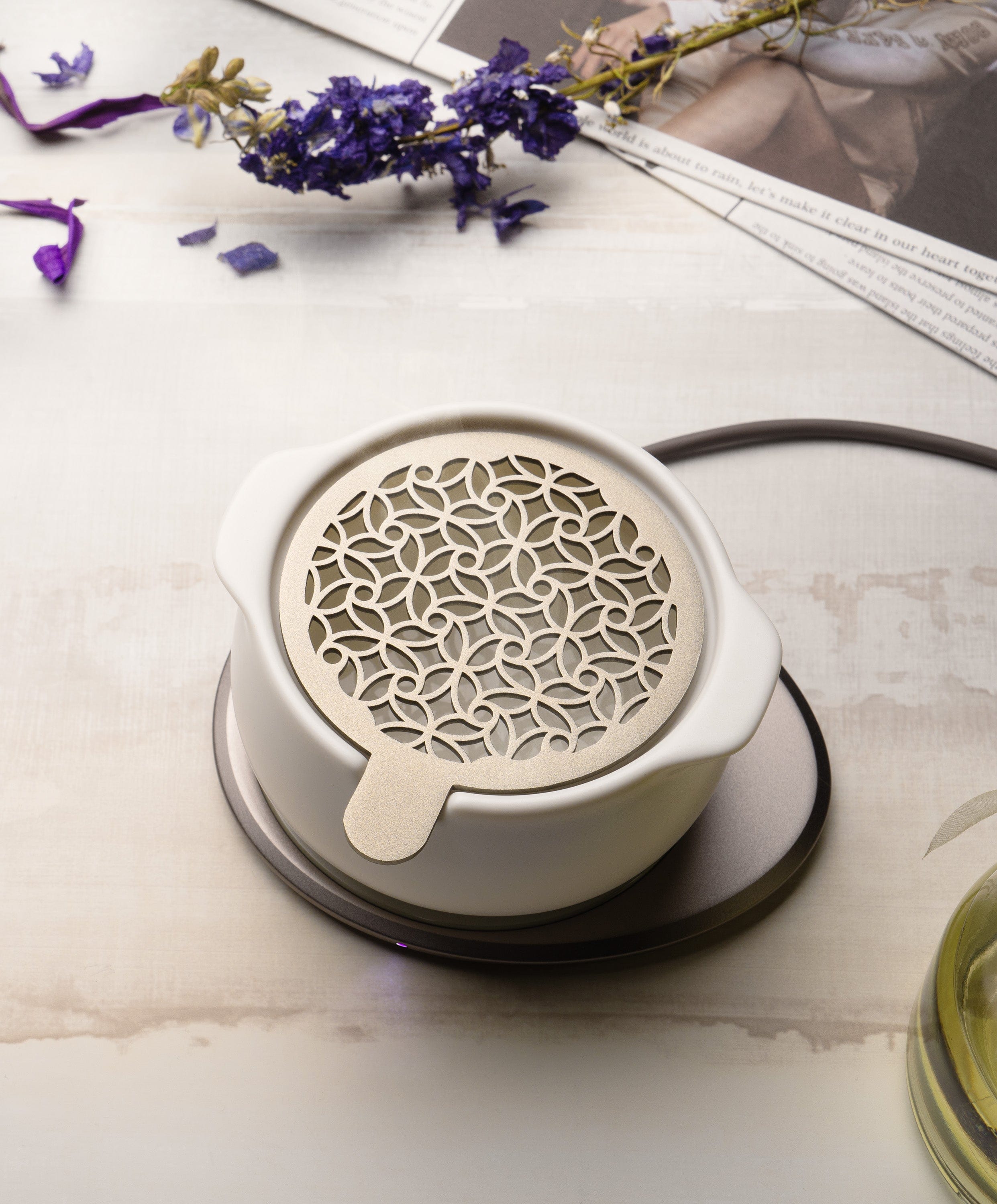 Jun self-heating diffuser styled on tabletop with dried botanicals