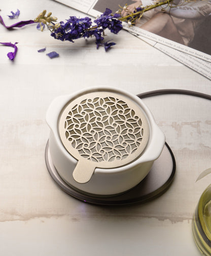 Jun self-heating diffuser styled on tabletop with dried botanicals