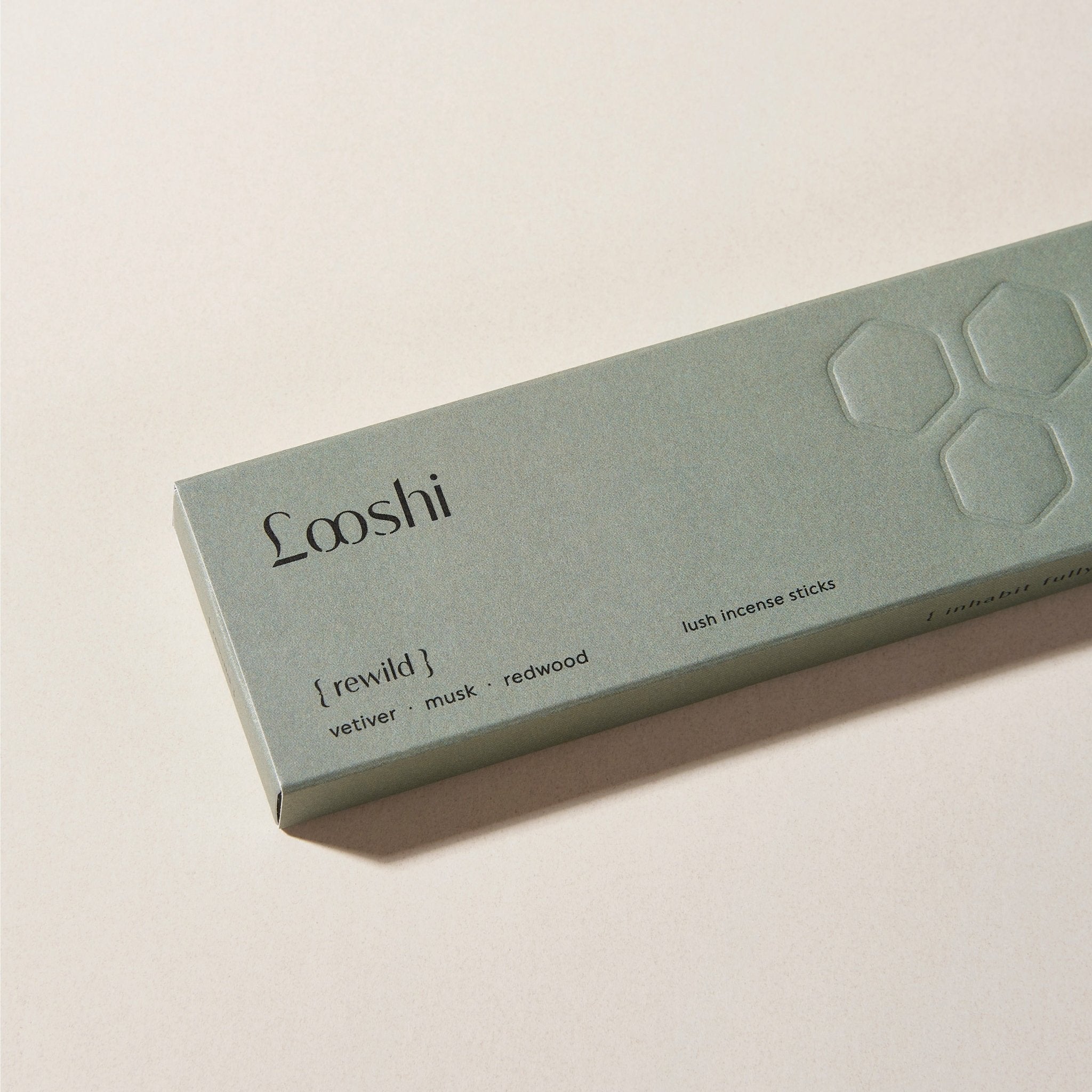 Sage green box of Looshi Rewild incense sticks on a cream surface, featuring vetiver, musk and redwood fragrances
