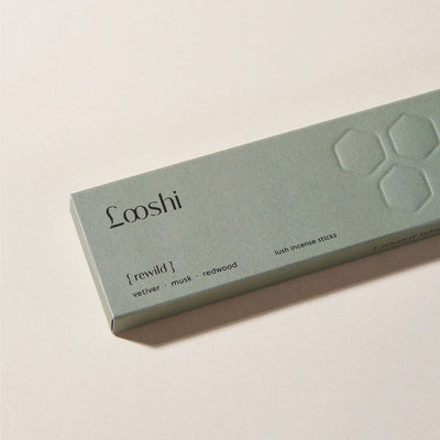 Sage green box of Looshi Rewild incense sticks on a cream surface, featuring vetiver, musk and redwood fragrances