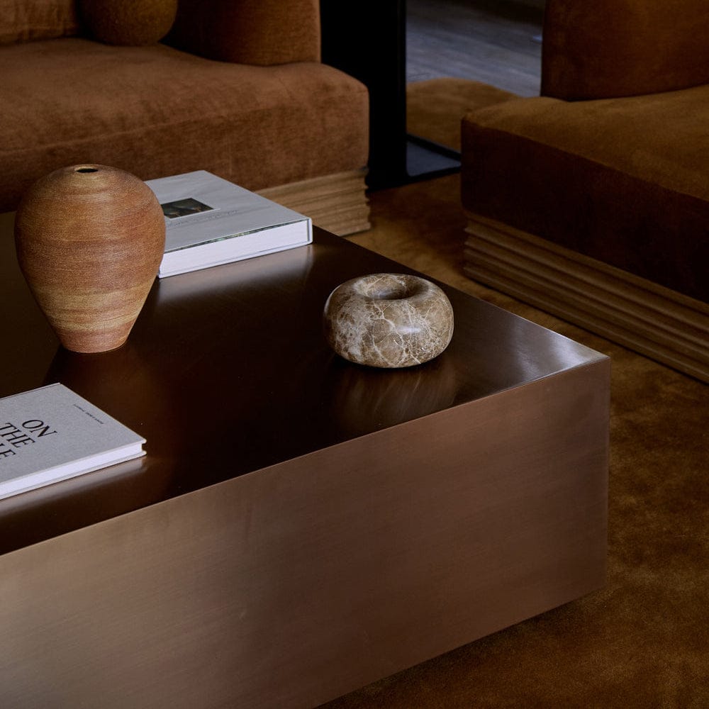 Brushed copper surface of copper coffee table reflecting warm light