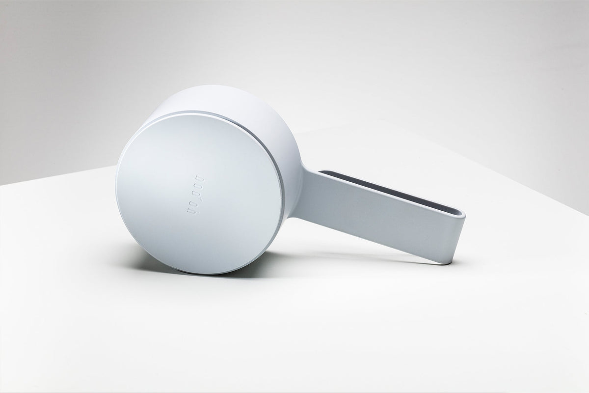 Mogo Scooper resting on its side to show the smooth circular base, rounded bowl, and thick straight handle.