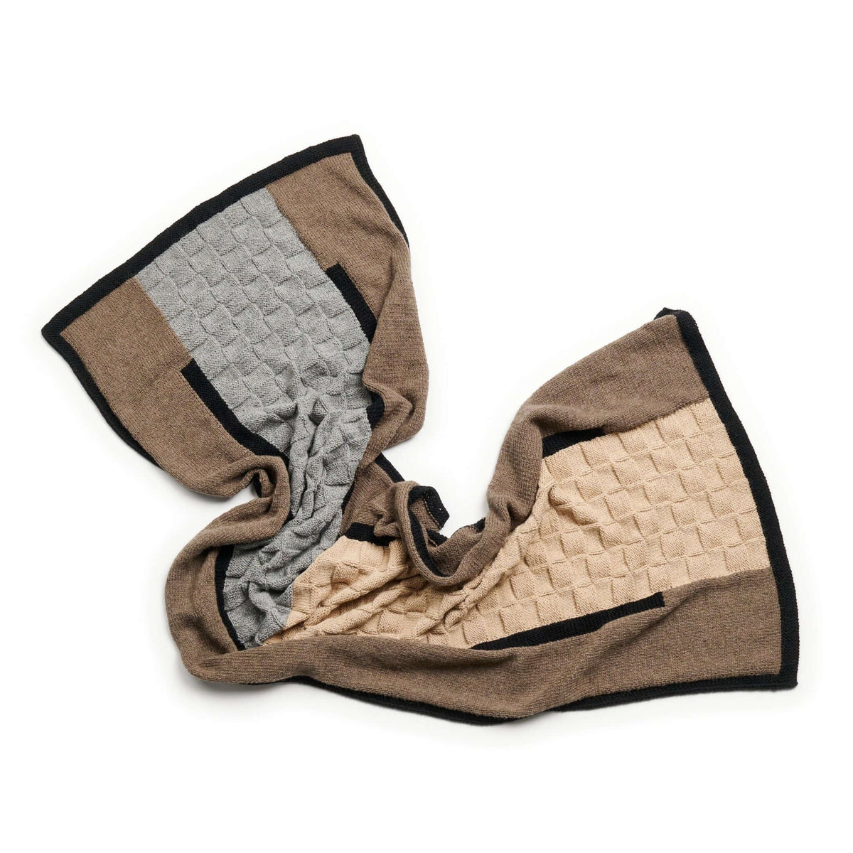 Loosely arranged alpaca blanket showing its flexible drape and mixed knitted textures.