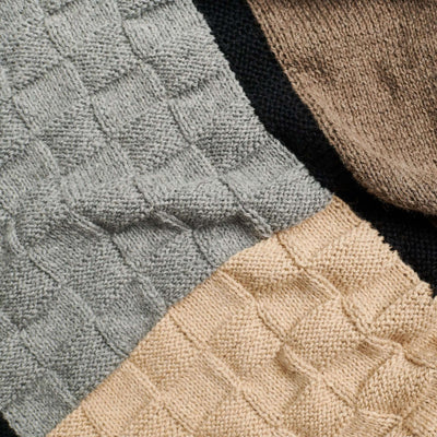 Close-up of the gray and beige basket-knit panels separated by a black border.