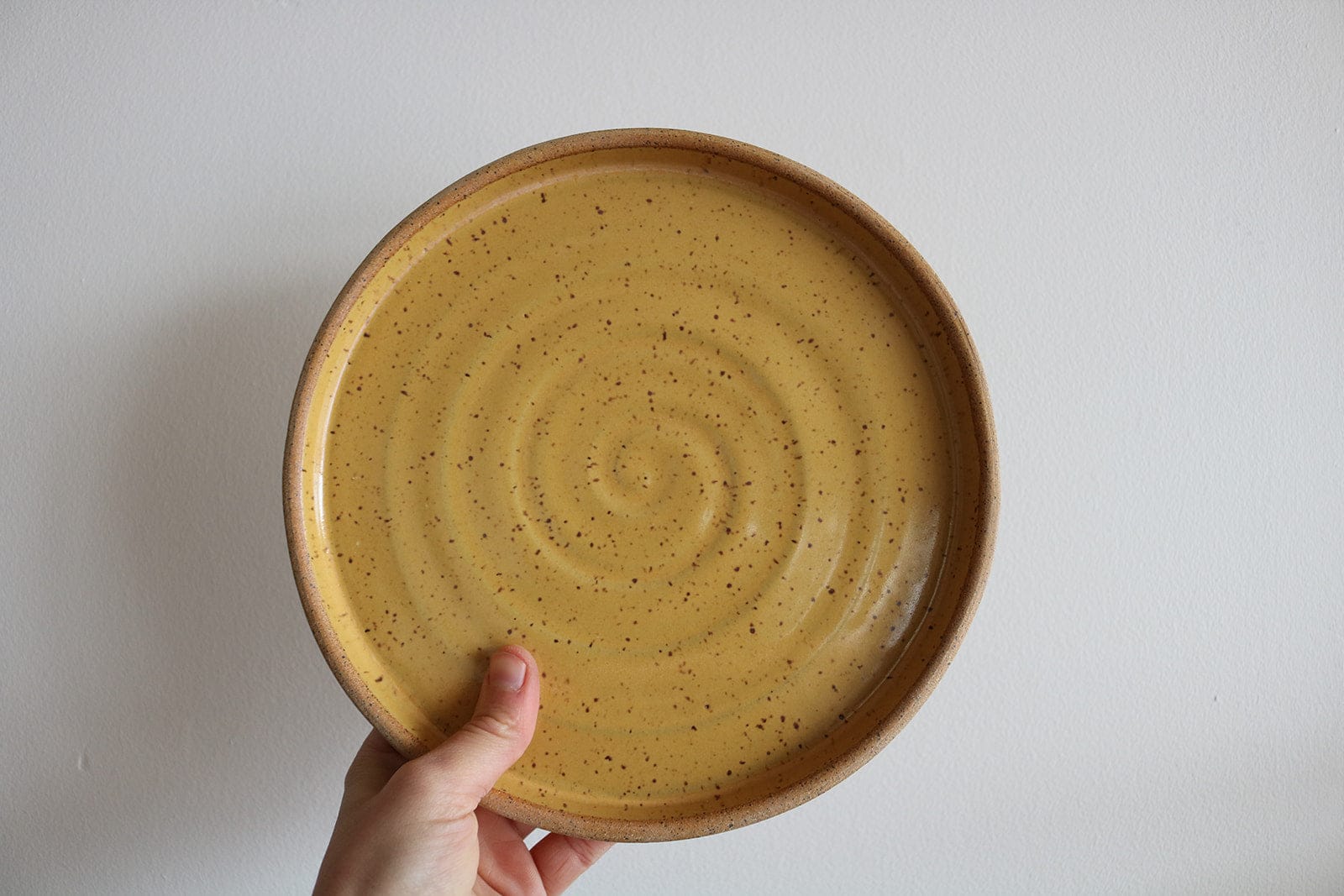 Mustard yellow handmade small ceramic plate with spiral texture
