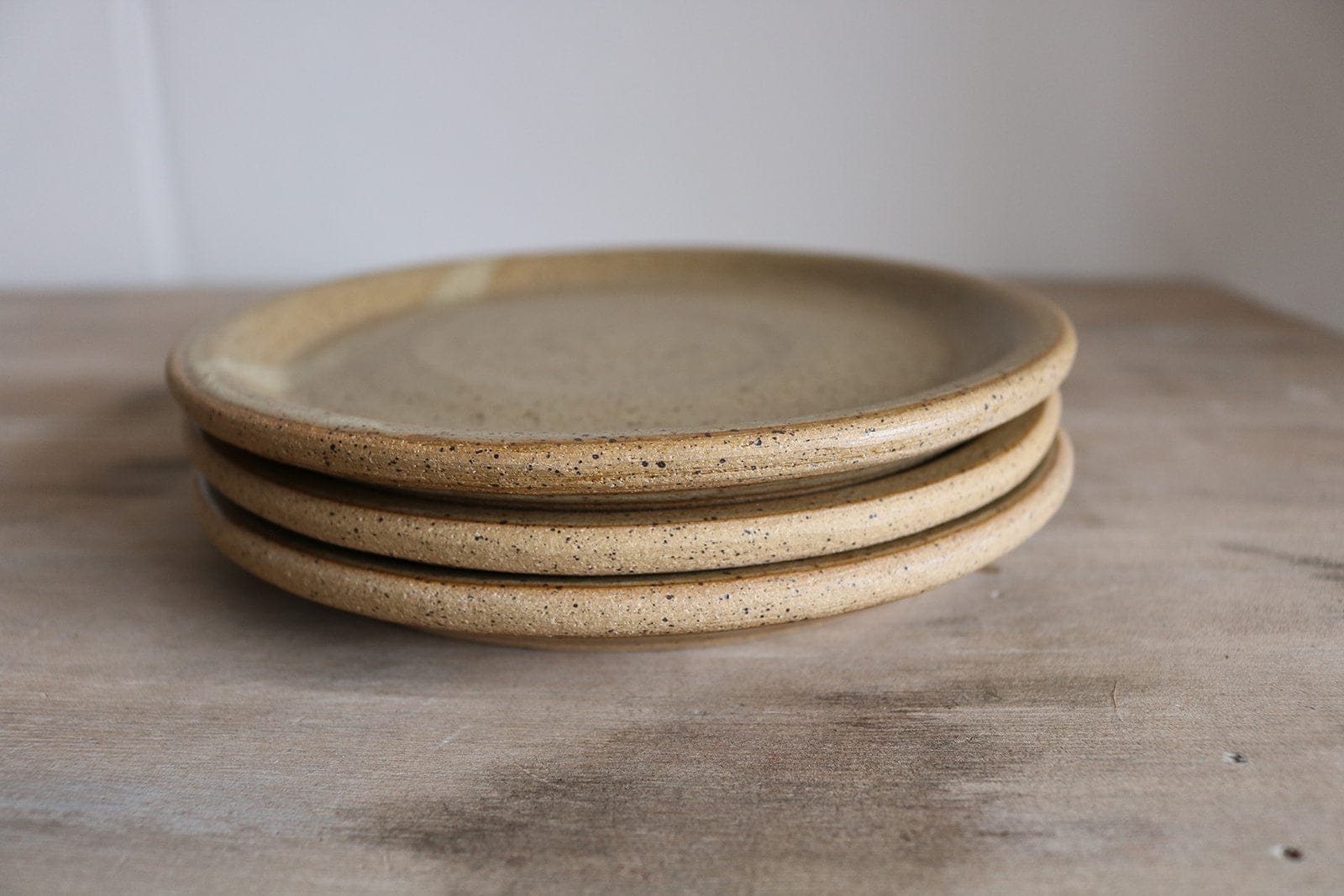 Neutral glazed handmade small plate stack on table