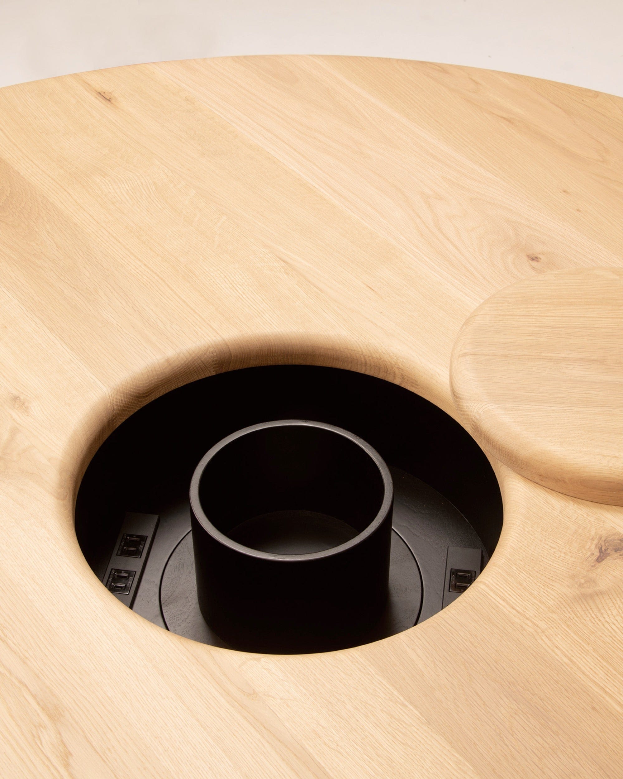ONE Round Table Japanese Oak Natural Close-up of concealed power outlet in round oak dining table