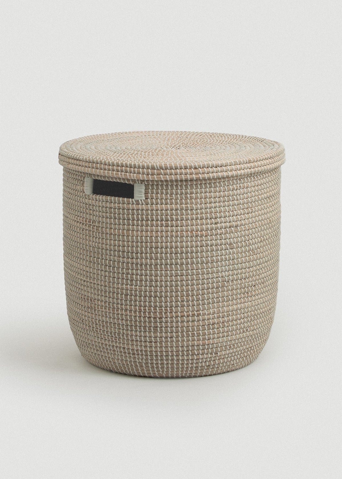 Large natural woven seagrass storage basket with a flat fitted lid and rectangular black side handle.