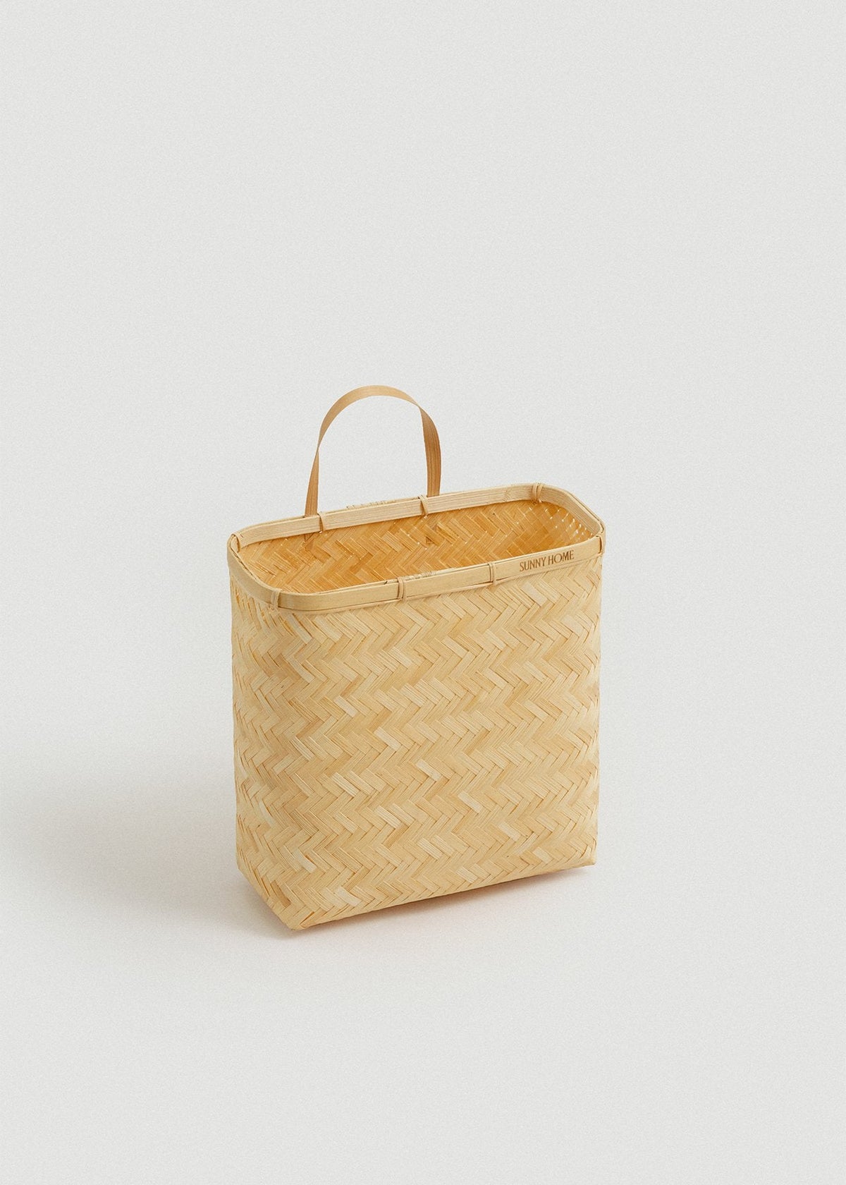 Angled front view of the Sapa wall basket showing its slim profile and open top.