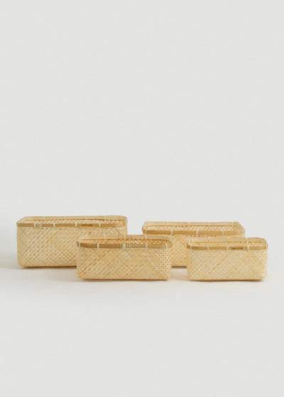 Set of four natural woven bamboo organizing baskets in graduated rectangular sizes.
