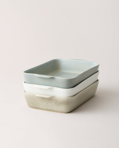 Blue-gray and warm stone Fieldstone Bakers stacked together, showing their compact rectangular shape, softly rounded corners, and contrasting glazes.