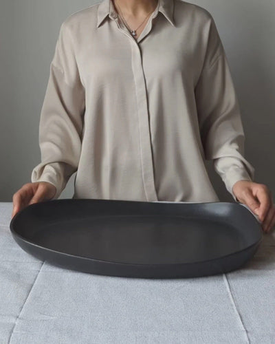 Gharyan Stoneware Japandi Tableware Long Serving Platter, black, held by person for scale