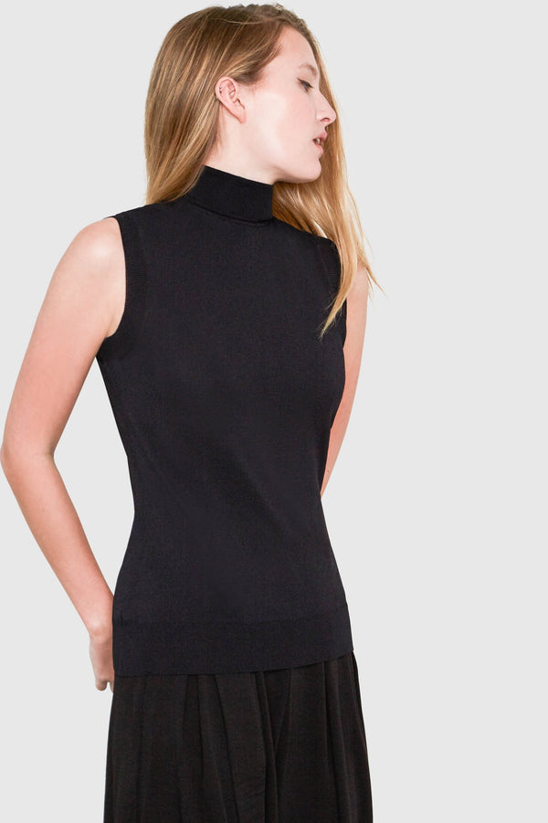 Santicler Hepburn Sleeveless Viscose Sweater in Black – model wearing sleeveless turtleneck sweater styled with a black skirt, side profile view, Japandi apparel essential