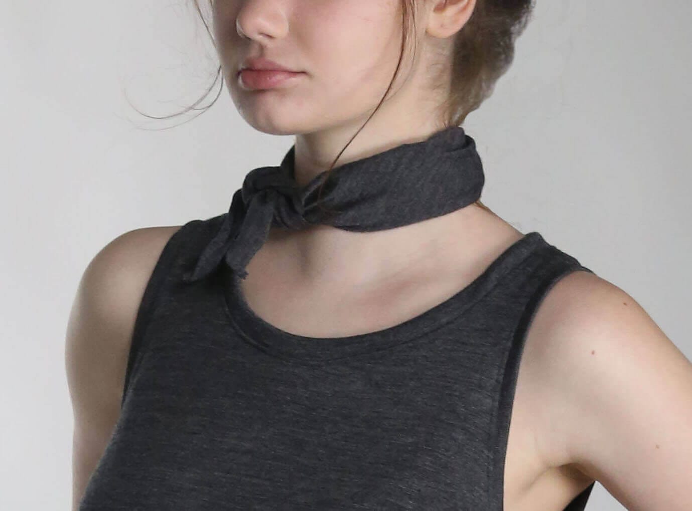 Woman wearing a merino wool bandana as a neck scarf, showcasing the versatile natural wool accessory.