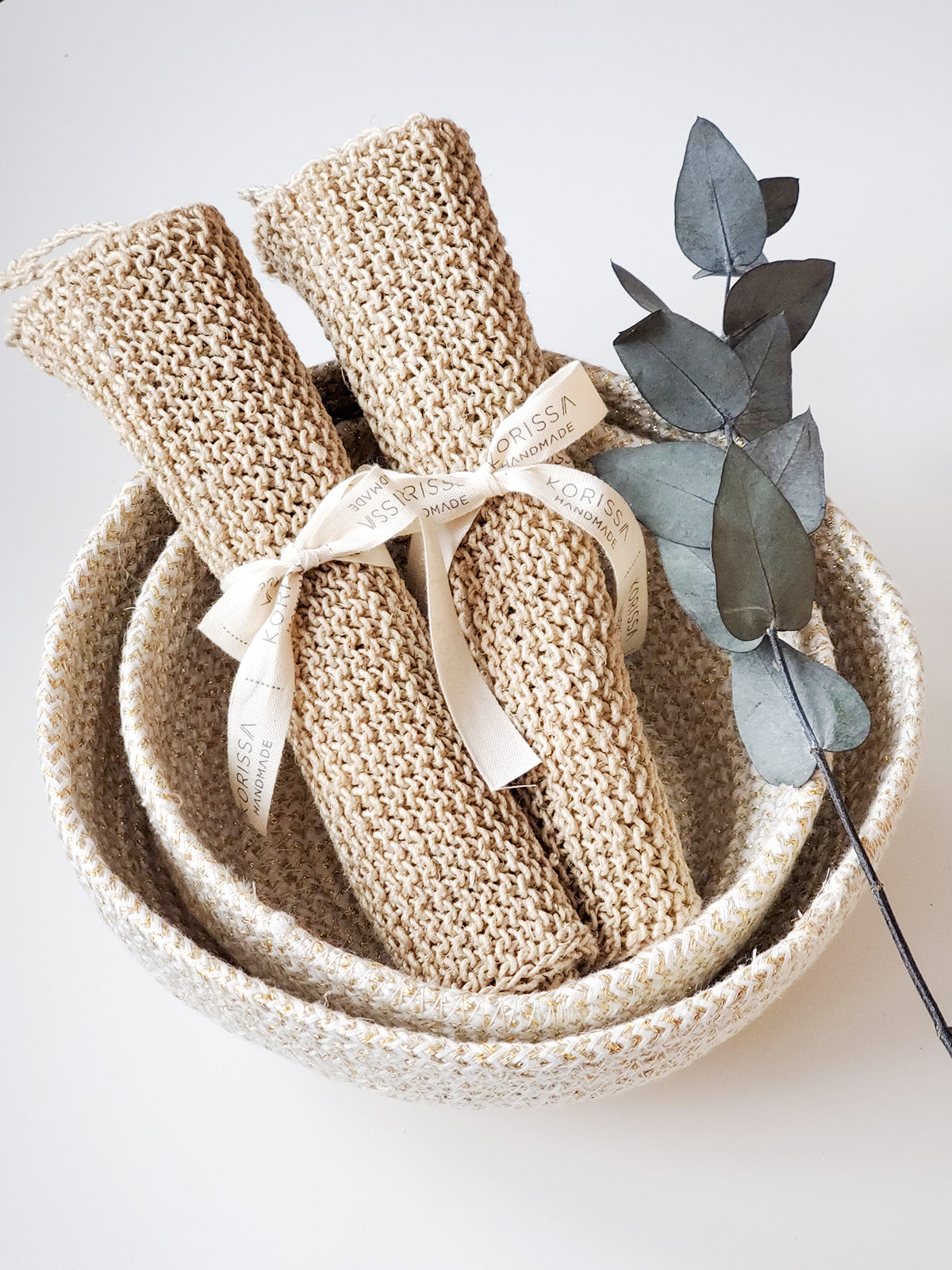 Korissa Hemp Washcloth rolled and tied with ribbon, eucalyptus sprig